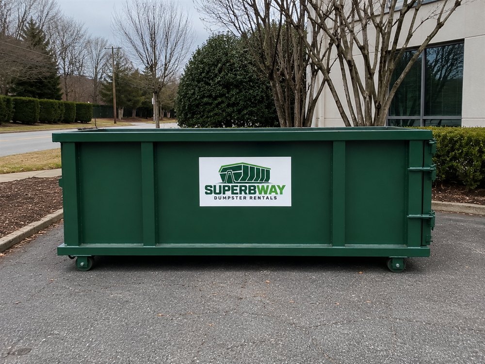 Green roll-off container set up for a residential cleanup